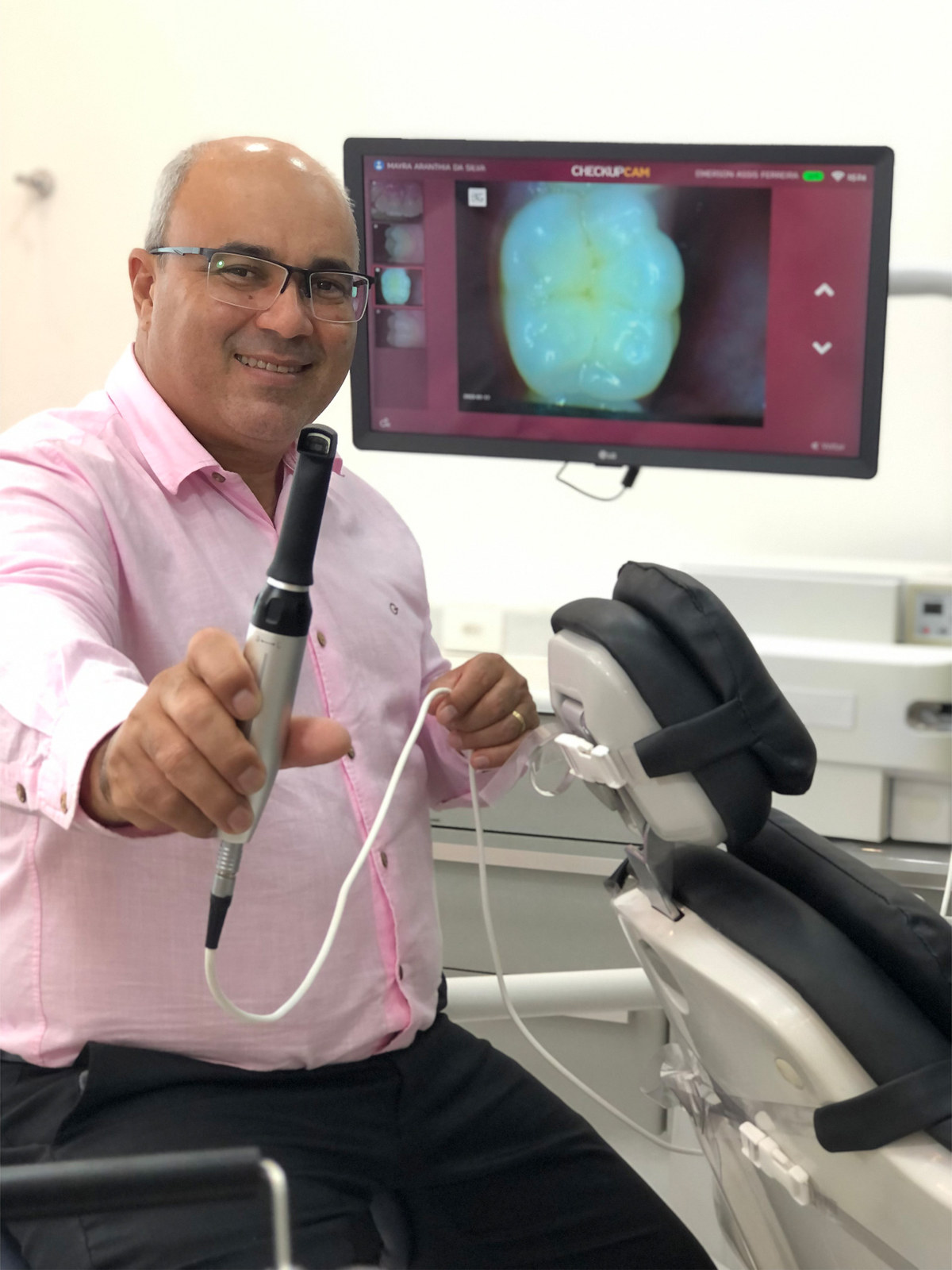 Câmera intraoral em uso pelo Dr. Emerson — diagnóstico em tela